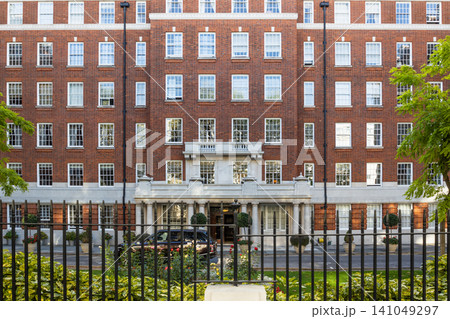 Traditional red brick residential apartment building facade in London with iron fence 141049297