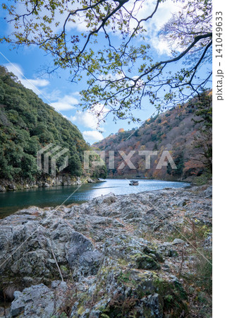 紅葉の嵐山・保津峡をゆったりと進む保津川下りの観光船 紅葉の嵐山・保津峡をゆったりと進む保津川下りの観光船 141049633