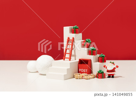 Festive Christmas mockup scene with white stepped display podiums, holiday figurines, and decorative props against a high-contrast red studio background, suitable for seasonal product advertising. Festive Christmas mockup scene with white stepped display podiums, holiday figurines, and decorative props against a high-contrast red studio background, suitable for seasonal product advertising. 141049855