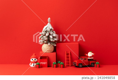 Christmas Scene with Snowy Pine Tree, Red Podium, Toy Truck, Snowman, Santa and Gifts on Red Background Christmas Scene with Snowy Pine Tree, Red Podium, Toy Truck, Snowman, Santa and Gifts on Red Background 141049858