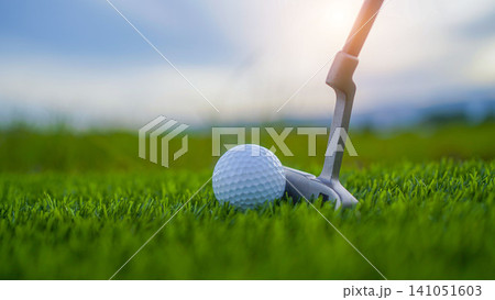 Golf clubs and balls on a green lawn in a beautiful golf course with morning sunshine. Golf clubs and balls on a green lawn in a beautiful golf course with morning sunshine. 141051603