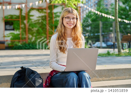 Happy teenage student with laptop on school campus Happy teenage student with laptop on school campus 141051859