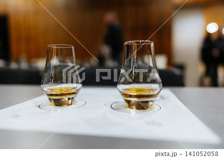 Whiskey tasting session featuring two elegant glasses in a cozy setting Whiskey tasting session featuring two elegant glasses in a cozy setting 141052058