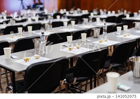 Glasses of whiskey await attendees in an empty conference hall during an event 141052075