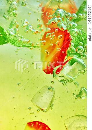 Strawberry mint sparkling drink with ice bubbles on green macro background. Strawberry mint sparkling drink with ice bubbles on green macro background. 141052194