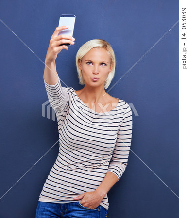 Influencer, selfie or kiss in social media, digital or memory as viral, update or post online. Woman, mouth or app as confident, fun or creative idea of connectivity on mockup on blue background Influencer, selfie or kiss in social media, digital or memory as viral, update or post online. Woman, mouth or app as confident, fun or creative idea of connectivity on mockup on blue background 141053039