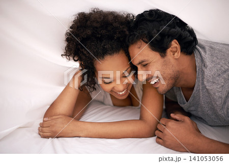 Couple, bed and sheet for relax morning with resting smile for partnership, bonding or apartment. Man, woman and happiness under linen for honeymoon laughter for vacation getaway, carefree or playful Couple, bed and sheet for relax morning with resting smile for partnership, bonding or apartment. Man, woman and happiness under linen for honeymoon laughter for vacation getaway, carefree or playful 141053056