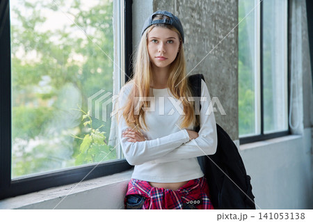 Confident teenage girl student with backpack smiling with folded arms Confident teenage girl student with backpack smiling with folded arms 141053138