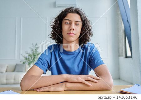 Smiling teen boy listening during online class Smiling teen boy listening during online class 141053146