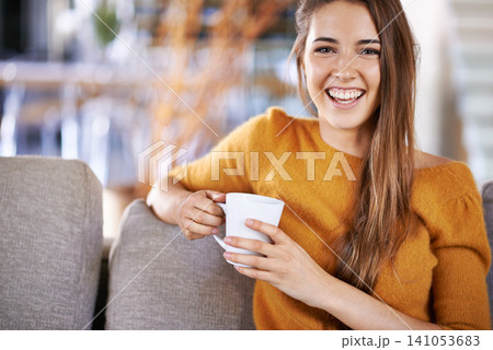 Woman, coffee and portrait on couch in home, peace and relax on weekend in apartment. Female person, happy and drinking tea or latte for self care, hot chocolate and resting on morning sofa in lounge 141053683