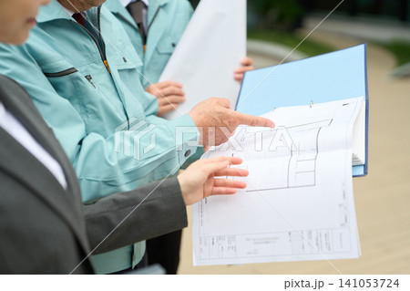 図面を見て確認をするアジア人の建設関係者 図面を見て確認をするアジア人の建設関係者 141053724