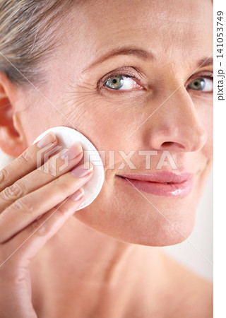 Mature woman, portrait or cotton for beauty in studio with facial cleaning, skincare or skin treatment. Model, person or swab for face detox, makeup removal or anti aging cosmetic on white background 141053749
