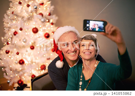Christmas, selfie and senior couple with love, holiday and support in home with social media. Happy, retirement and marriage with smile and profile picture in house with celebration and santa hat Christmas, selfie and senior couple with love, holiday and support in home with social media. Happy, retirement and marriage with smile and profile picture in house with celebration and santa hat 141053862