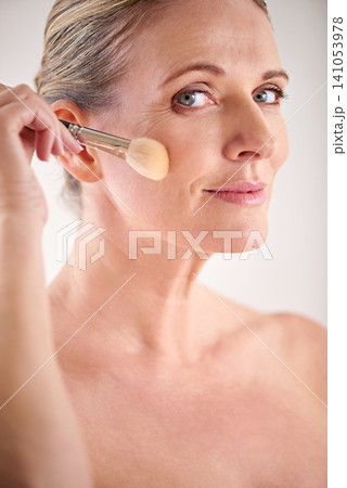 Brush, cosmetic and portrait of woman in studio for makeup, self care and facial glow routine. Beauty, foundation and mature female person with cosmetology tool for face treatment by white background Brush, cosmetic and portrait of woman in studio for makeup, self care and facial glow routine. Beauty, foundation and mature female person with cosmetology tool for face treatment by white background 141053978