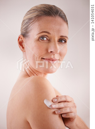 Mature woman, cream and studio with treatment, portrait and cosmetic with skincare. Model, beauty and luxury with body, cosmetics and care for anti ageing and healthy skin for wellness and confidence 141054031