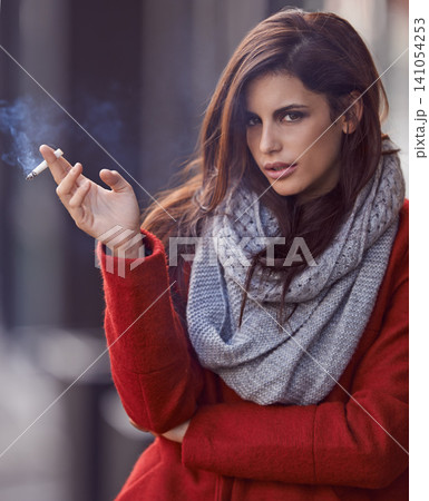 Portrait, winter and woman with a cigarette, outdoor and cold weather with a bad habit in New York city. Face, person and girl smoking, fashion and casual outfit with season and tobacco with style 141054253