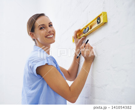 Level, wall and portrait of woman in house for interior design or renovation project and tools to align. Female person, remodeling and diy for home improvement or development and repair for upgrade Level, wall and portrait of woman in house for interior design or renovation project and tools to align. Female person, remodeling and diy for home improvement or development and repair for upgrade 141054382
