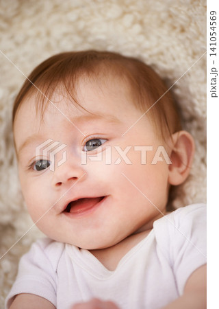 Happy, sweet and closeup of baby on blanket playing for child development and curious face. Smile, cute and young girl kid, infant or newborn relaxing and laying on bed in nursery room at home. Happy, sweet and closeup of baby on blanket playing for child development and curious face. Smile, cute and young girl kid, infant or newborn relaxing and laying on bed in nursery room at home. 141054569