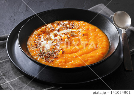 spiced sweet potato soup in a black bowl spiced sweet potato soup in a black bowl 141054901