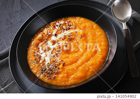 spiced sweet potato soup in a black bowl 141054902