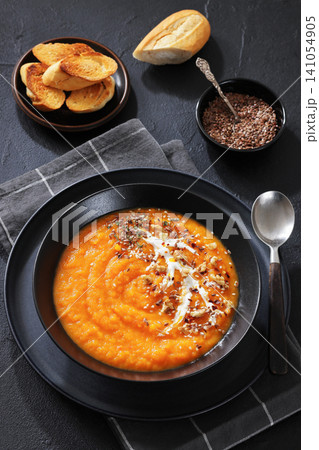 spiced sweet potato soup in a black bowl spiced sweet potato soup in a black bowl 141054905