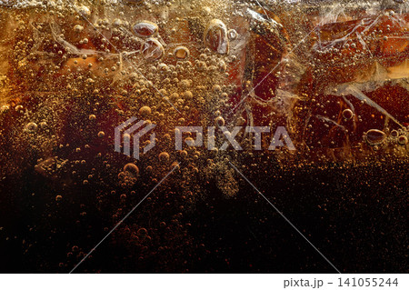 Iced caramel soft drink with sparkling bubbles and dark texture. Iced caramel soft drink with sparkling bubbles and dark texture. 141055244