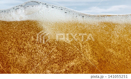 Foamy beer surface with golden carbonation and bubbles Foamy beer surface with golden carbonation and bubbles 141055251