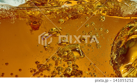 Beer glass macro with golden bubbles and foam line. Beer glass macro with golden bubbles and foam line. 141055252