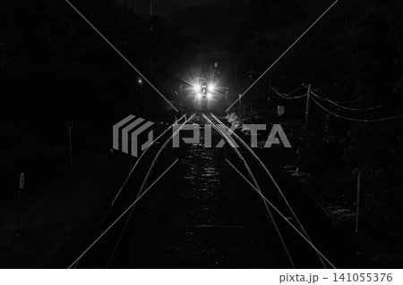 漆黒の闇に包まれた夜の函館本線をヘッドライトの強い光を放ち進む列車 漆黒の闇に包まれた夜の函館本線をヘッドライトの強い光を放ち進む列車 141055376