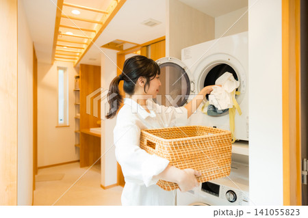 乾燥機から洗濯物を取り出す女性 乾燥機から洗濯物を取り出す女性 141055823