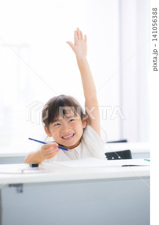 明るい教室で笑顔で手を挙げて発表する小学生の女の子・授業や積極性を表現した教育イメージ わかる人~! 明るい教室で笑顔で手を挙げて発表する小学生の女の子・授業や積極性を表現した教育イメージ わかる人~! 141056388
