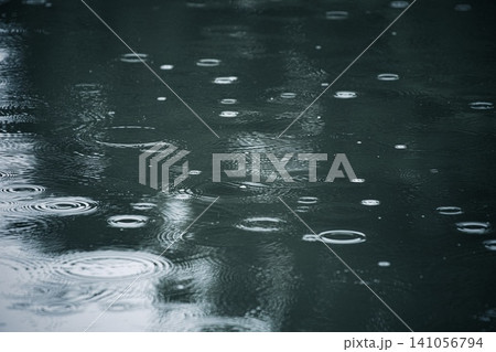 水に落ちる雨粒と水面にできた波紋 水に落ちる雨粒と水面にできた波紋 141056794