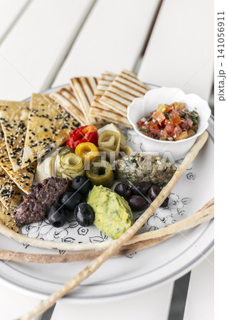 mixed vegan vegetarian mediterranean tapas snack platter on white table in outdoor cafe mixed vegan vegetarian mediterranean tapas snack platter on white table in outdoor cafe 141056911