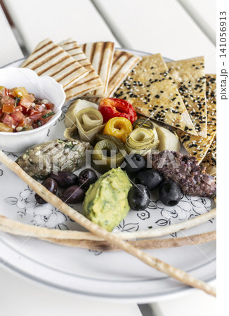 mixed vegan vegetarian mediterranean tapas snack platter on white table in outdoor cafe 141056913
