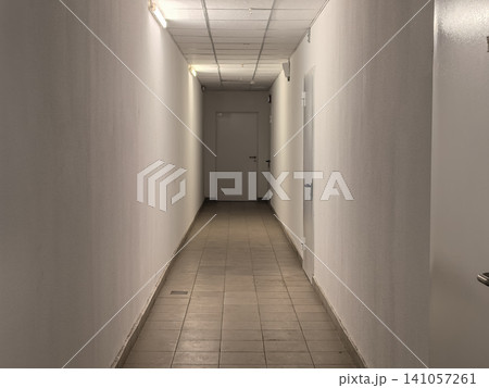 Empty white corridor with tiled floor and closed door in office building Empty white corridor with tiled floor and closed door in office building 141057261