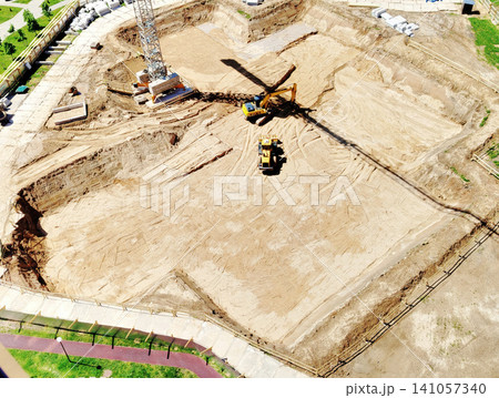 Aerial View Construction Site With Excavator and Crane Shadow Preparing Foundation and Earthworks Aerial View Construction Site With Excavator and Crane Shadow Preparing Foundation and Earthworks 141057340