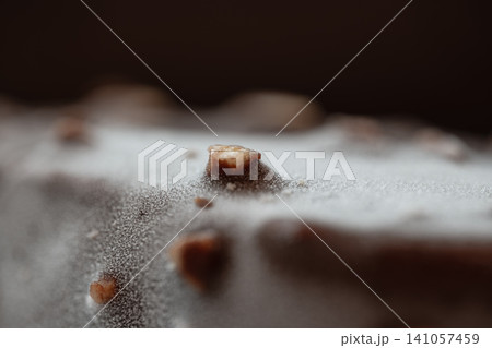 Frozen chocolate bar with almond pieces and frost on its surface Frozen chocolate bar with almond pieces and frost on its surface 141057459