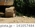 工事現場の地面に力強く佇む、土に汚れた重機のクローラー、キャタピラ（無限軌道） 141057484