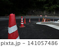 新しく舗装された道路のカーブに並ぶ赤と白のカラーコーン 141057486