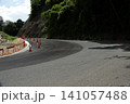 青空の下の山道に新しく舗装されたきれいなアスファルトのカーブ 141057488