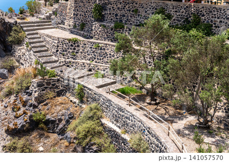 Stone steps and terraced walls on a volcanic hillside in Santorini 141057570