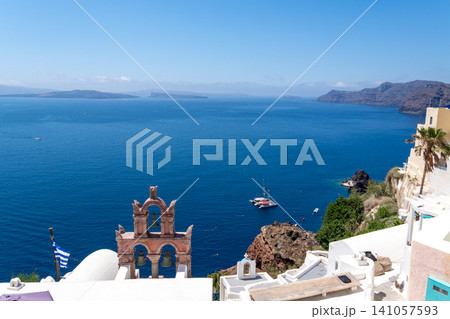 Pink orthodox bell tower overlooking Santorini caldera and Aegean Sea Pink orthodox bell tower overlooking Santorini caldera and Aegean Sea 141057593