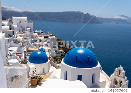 Scenic blue domes of Oia over Santorini volcanic caldera Greece Scenic blue domes of Oia over Santorini volcanic caldera Greece 141057601