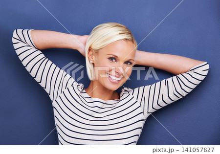 Woman, stretching and relax in portrait with fashion, style or confidence in studio on blue background. Happy, girl and pride as professional art director in business or designer for project Woman, stretching and relax in portrait with fashion, style or confidence in studio on blue background. Happy, girl and pride as professional art director in business or designer for project 141057827