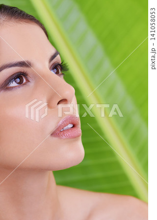 Woman, thinking and beauty with makeup, cosmetics and skincare with plant and green background. Wellness, care and facial treatment with female person and leaf with dermatology and skin glow Woman, thinking and beauty with makeup, cosmetics and skincare with plant and green background. Wellness, care and facial treatment with female person and leaf with dermatology and skin glow 141058053