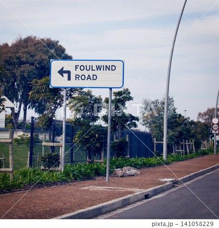 Signage for wind, road and city with information, outdoor and nature with urban town and design. Direction, icon and street with symbol and trees with poster and language with bushes and board 141058229
