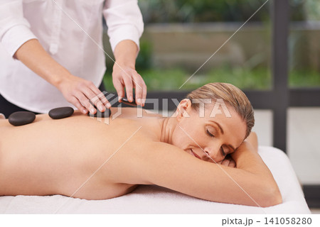 Girl, spa and hands with hot stone for massage, wellness and relax in hotel. Physical therapy, holistic and female person in holiday or vacation in California for health, peace and back skin detox Girl, spa and hands with hot stone for massage, wellness and relax in hotel. Physical therapy, holistic and female person in holiday or vacation in California for health, peace and back skin detox 141058280