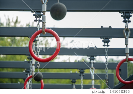 Gymnastic rings on outdoor obstacle course Gymnastic rings on outdoor obstacle course 141058396
