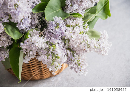 Close up of blooming lilac flowers in wicker basket 141058425