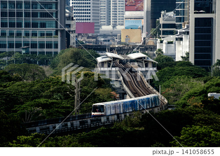 Modern Sky Train Moving Through Lush Green Trees in City Modern Sky Train Moving Through Lush Green Trees in City 141058655